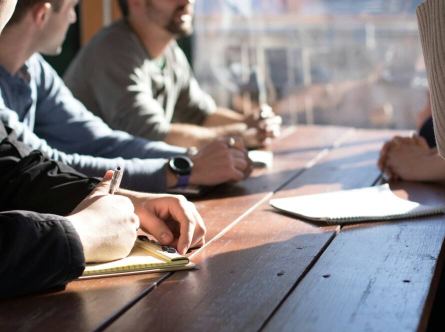 Rapat bisnis di meja dengan catatan dan dokumen, ilustrasi persiapan SPT Tahunan badan