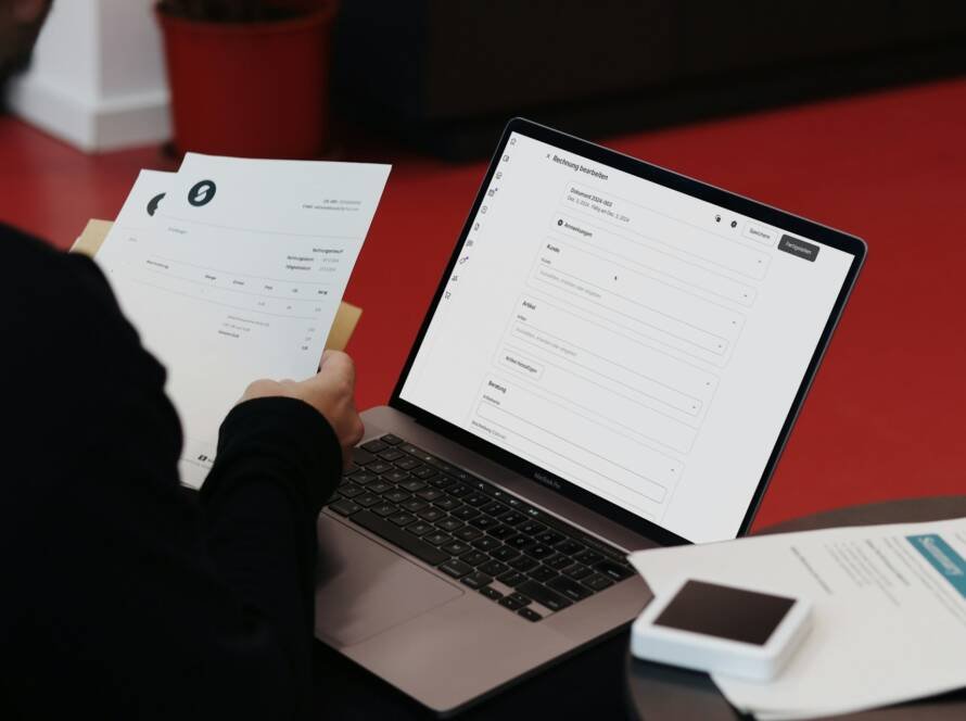 Seseorang menulis di dokumen di samping laptop, ilustrasi pembetulan SPT