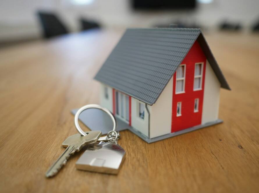 Miniatur rumah dan kunci di atas meja kayu, ilustrasi cara mengisi daftar harta SPT Tahunan